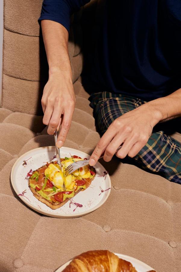 Sanderson Лондон Екстер'єр фото A person using a knife and fork to cut food